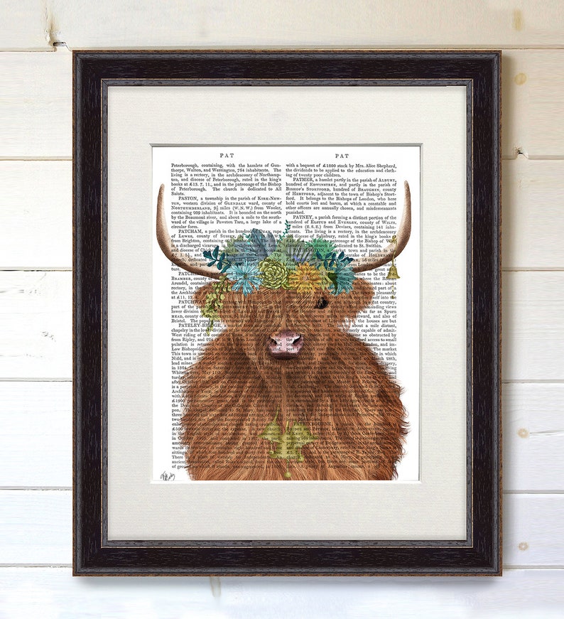 May include: A Highland cow with a floral crown made of succulents and flowers on a vintage book page background. The cow is brown and white with a fluffy coat. The text on the page is in black and white.