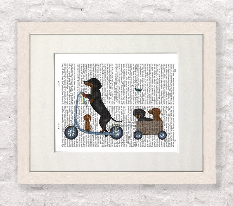 May include: A black and brown dachshund dog riding a blue scooter with two other dachshund dogs in a wooden wagon behind it. The dogs are on a printed page background.