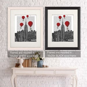 K&ouml;nnte beinhalten: Zwei gerahmte Drucke einer Schwarzwei&szlig;illustration des Empire State Building mit roten Hei&szlig;luftballons, die dar&uuml;ber fliegen. Der Druck links ist in Wei&szlig; gerahmt und der Druck rechts in Schwarz. Beide Rahmen sind 40,64 cm x 50,8 cm gro&szlig;.