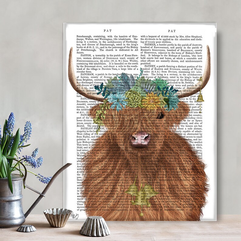 May include: A Highland cow with a floral crown made of succulents and flowers. The cow is brown and white and has a long, shaggy coat. The background is a vintage book page with text about the town of Patney, England.