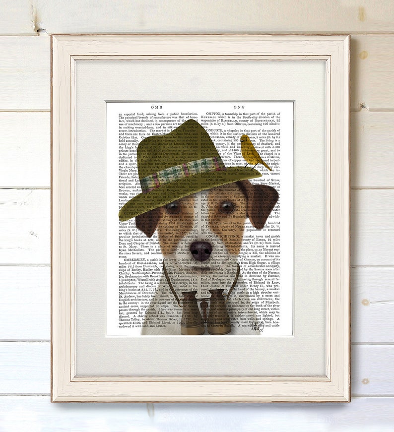 May include: A brown and white Jack Russell Terrier wearing a green and brown hat with a plaid band, binoculars, and a yellow bird perched on the hat. The dog is looking at the camera. The background is a vintage book page.