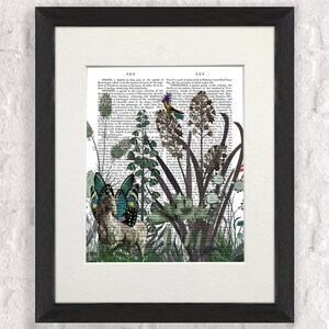 Puede incluir: Una p&aacute;gina de libro vintage con una ilustraci&oacute;n caprichosa de un ciervo, mariposas y un p&aacute;jaro en un entorno de jard&iacute;n. El texto de la p&aacute;gina es de un antiguo diccionario, con las palabras "PEN" y "FEN" visibles.