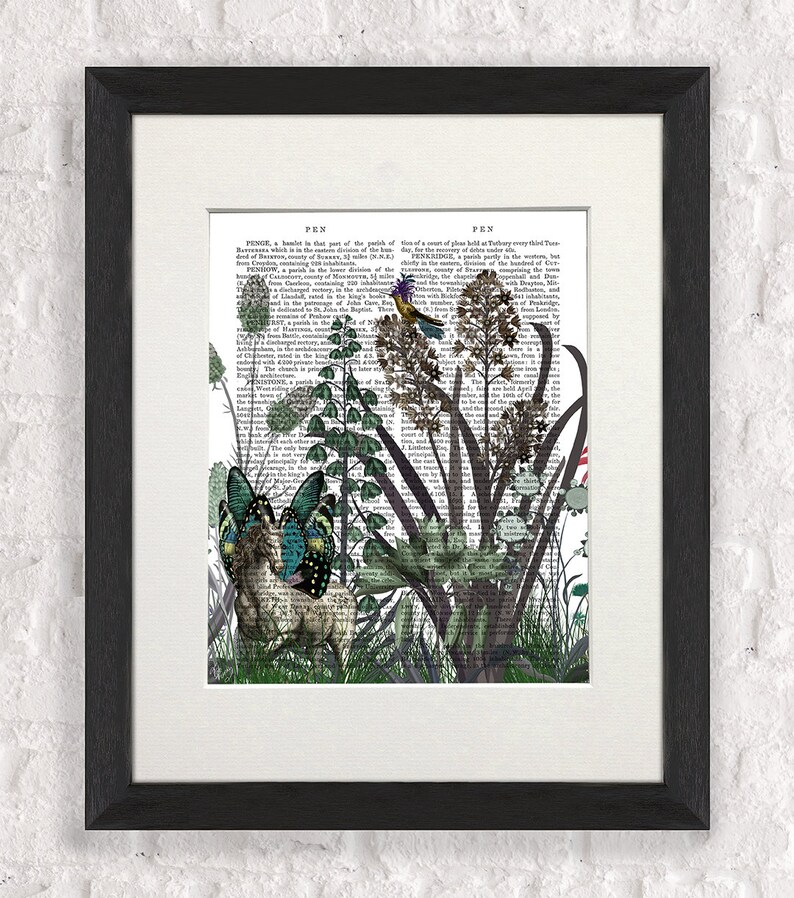 Puede incluir: Una p&aacute;gina de libro vintage con una ilustraci&oacute;n caprichosa de un ciervo, mariposas y un p&aacute;jaro en un entorno de jard&iacute;n. El texto de la p&aacute;gina es de un antiguo diccionario, con las palabras "PEN" y "FEN" visibles.