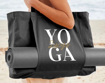 May include: Black yoga tote bag with white text that says "YOGA" with the name "Lucy's" written in gold script underneath. The bag has a gray yoga mat tucked into the side pocket.
