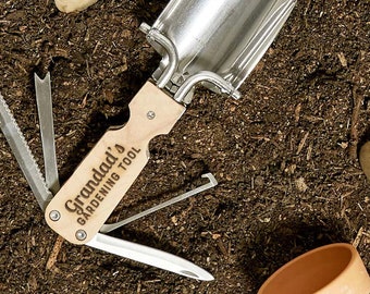 May include: A multi-tool gardening tool with a wooden handle and a metal shovel head. The handle is engraved with the text "Granddad's Gardening Tool".