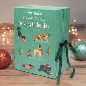 Könnte beinhalten: Ein türkisfarbener Adventskalender mit Illustrationen von Hunden in festlicher Kleidung. Die Box ist mit Schneeflocken und dem Text "Francesca's Festive Friends Advent Calendar" in goldfarbenen Buchstaben verziert. Ein dunkelgrünes Band ist um die Box gebunden.