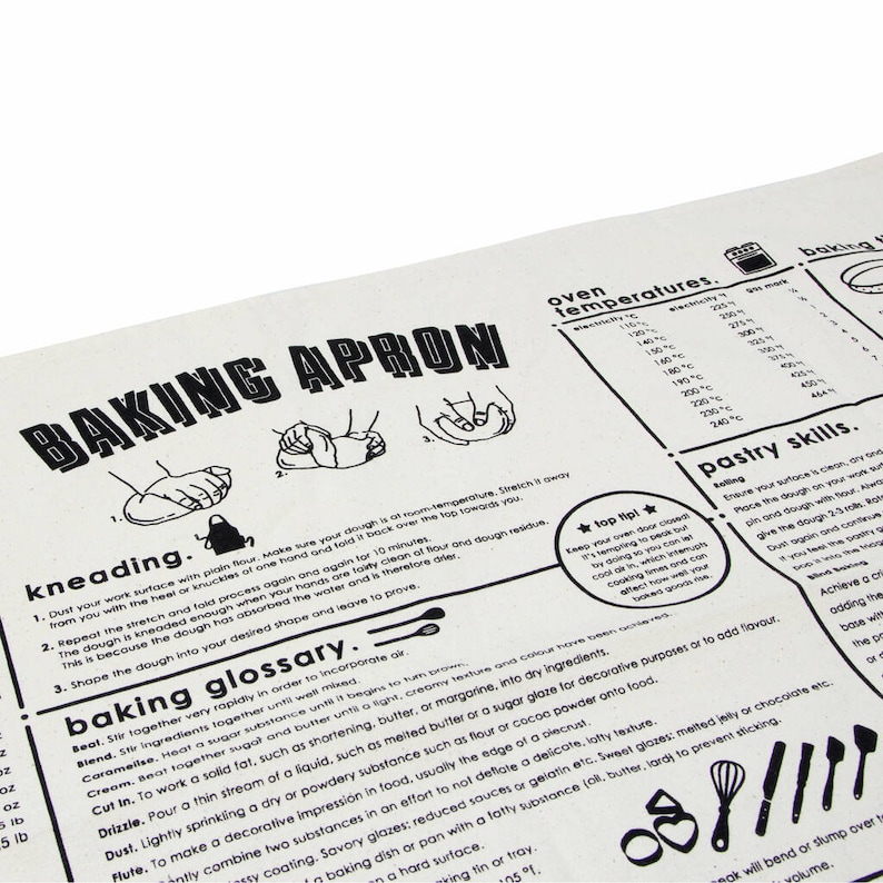 Puede incluir: Delantal de cocina blanco y negro con ilustraciones de amasar la masa y una tabla de temperaturas del horno. El texto "Baking Apron" est&aacute; en letras grandes y negritas en la parte superior del delantal. El delantal tambi&eacute;n incluye un glosario de t&eacute;rminos de reposter&iacute;a.