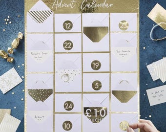 May include: Gold and white Advent calendar with numbered envelopes. The calendar has the text "Advent Calendar" at the top and the name "Jessica's" at the bottom. Some envelopes have text like "Romantic Dinner for two" and "A Day at the Spa".