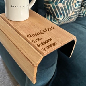 May include: A wooden armrest tray with the text "Nanny's Spot!" and a checklist with the items "Tea", "Biscuits", and "Sudoku".