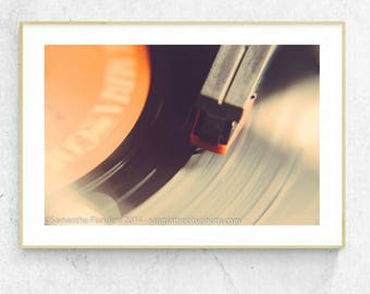 May include: Close-up of a vintage record player with a red needle playing a vinyl record. The record label is orange and has the text "What A" on it.
