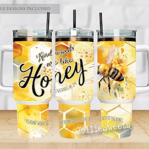 May include: Three stainless steel tumblers with a honeycomb pattern and bee design. The tumblers have a white background with yellow and gold accents. The text on the tumblers reads "Kind words are like honey" and "Proverbs 16:24".