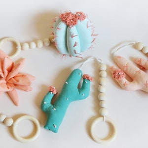 Brinquedos de ginástica para bebês com cactos: decoração de berçário em tons pastel do sudoeste