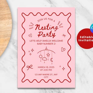 May include: Pink baby shower invitation with red text. The invitation says "Join us for a Nesting Party" and "Let's help Amelia welcome baby number 21". The invitation also includes a mobile with stars, clouds, and a crescent moon.