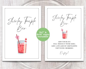 May include: Two white framed signs with the text "Shirley Temple Bar". One sign features a Shirley Temple drink illustration. The other sign includes instructions: "Add your ice, fill mostly with soda, add a splash of grenadine, top with cherries. Enjoy!"