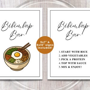 May include: Two white framed signs with the words "Bibimbap Bar" in elegant script. One sign features a bowl of bibimbap with chopsticks. The other sign lists instructions: Start with rice, add vegetables, pick a protein, top with sauce, mix & enjoy.