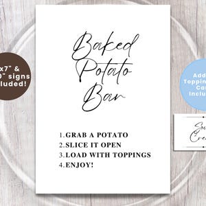May include: A white sign with the words "Baked Potato Bar" in elegant script. Instructions are listed below. Additional signs and topping food cards are included. The sign is on a light wood surface.