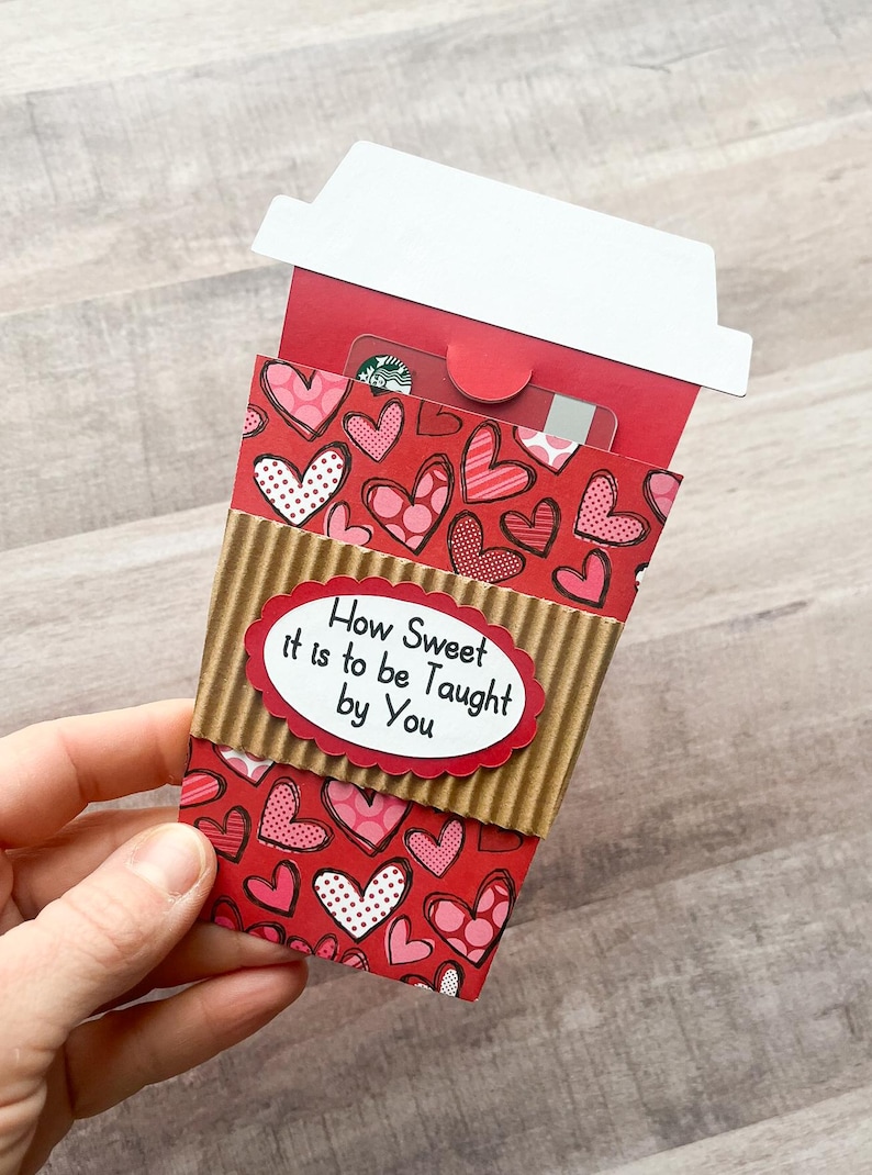 May include: A red and brown paper coffee cup with a heart pattern and the text "How Sweet it is to be Taught by You".