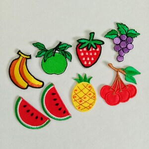 Pode incluir: Uma coleção de patches de frutas bordadas, incluindo banana, maçã verde, morango, uvas, fatias de melancia, abacaxi e cerejas. Cada patch apresenta cores vibrantes e costuras detalhadas, perfeito para adicionar um toque divertido a roupas ou acessórios.