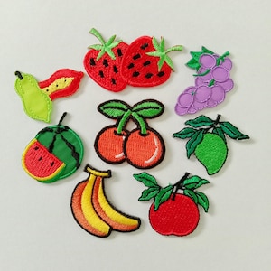 May include: A collection of embroidered fruit patches, including strawberries, grapes, cherries, watermelon, bananas, an apple, and a pear. Each patch features detailed stitching and vibrant colors, perfect for adding a touch of whimsy to clothing or accessories.