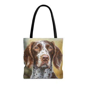 May include: Tote bag featuring a detailed portrait of a German Shorthaired Pointer. The dog has brown and white markings, with a focused gaze. The bag has black handles and a cream-colored background.