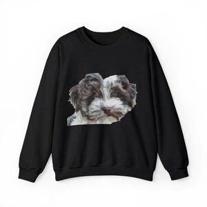 May include: Black sweatshirt featuring a detailed image of a puppy's face. The puppy has brown and white fur, with a focused expression. The sweatshirt is a solid black color, providing a contrast to the puppy's image.