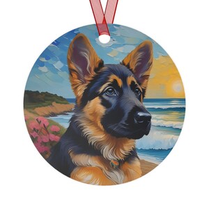 May include: A round, colorful ornament featuring a German Shepherd puppy with brown and black fur. The puppy is looking at the viewer with a sweet expression. The background is a painted scene of a beach with blue water and a yellow sunset.