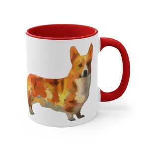 Könnte beinhalten: Weiße Keramik-Kaffeetasse mit rotem Rand und Henkel. Die Tasse zeigt eine farbenfrohe Illustration eines Pembroke Welsh Corgi.