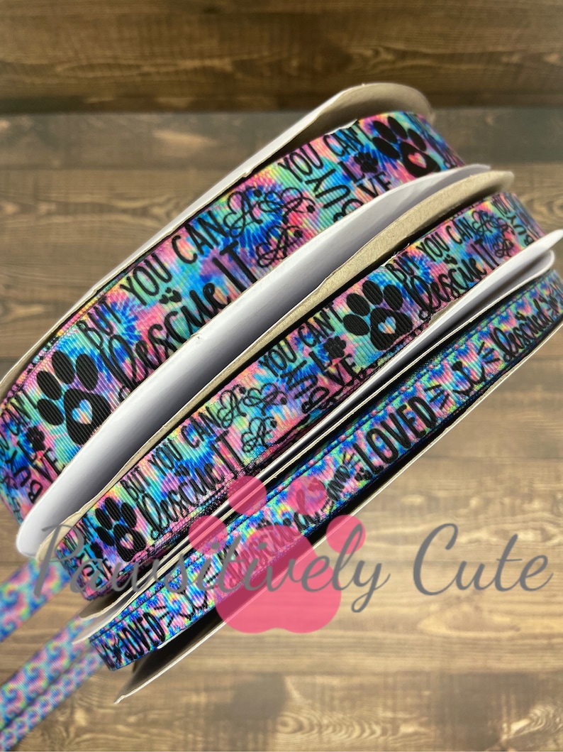 Peut inclure: Trois rouleaux de ruban &agrave; motif tie-dye color&eacute; avec des empreintes de pattes noires et du texte qui dit "Mais vous ne pouvez pas le sauver parce que vous ne pouvez pas l'acheter" et "Aim&eacute; = Sauv&eacute;".