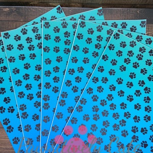 May include: Five sheets of blue and black patterned vinyl with a gradient of blue from dark to light. The pattern is a repeating paw print design.