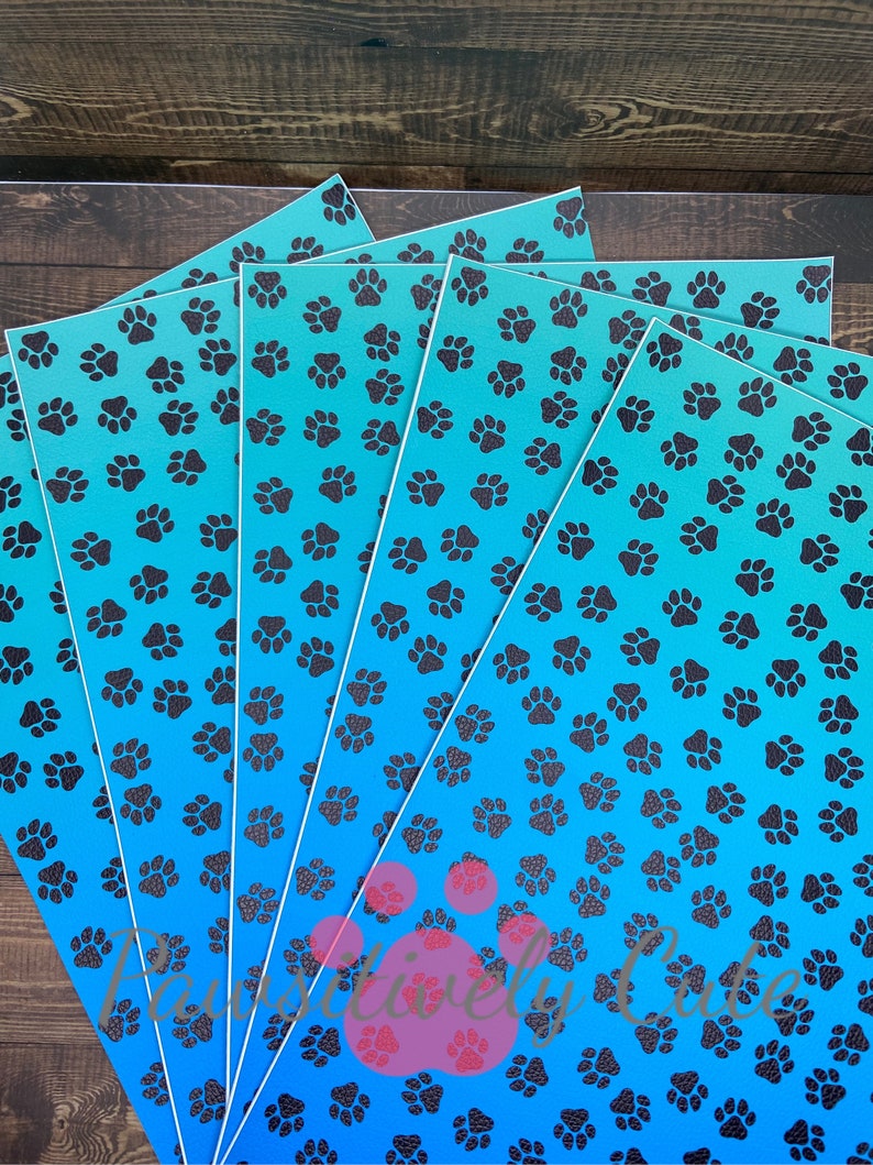 May include: Five sheets of blue and black patterned vinyl with a gradient of blue from dark to light. The pattern is a repeating paw print design.