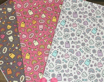 Peut inclure: Trois feuilles de papier de scrapbooking sur le thème d'Halloween avec un fond rose, blanc et gris. Chaque feuille présente un motif répétitif de fantômes, d'arcs-en-ciel, de maïs sucré, de chauves-souris, d'étoiles et le mot "BOO!"
