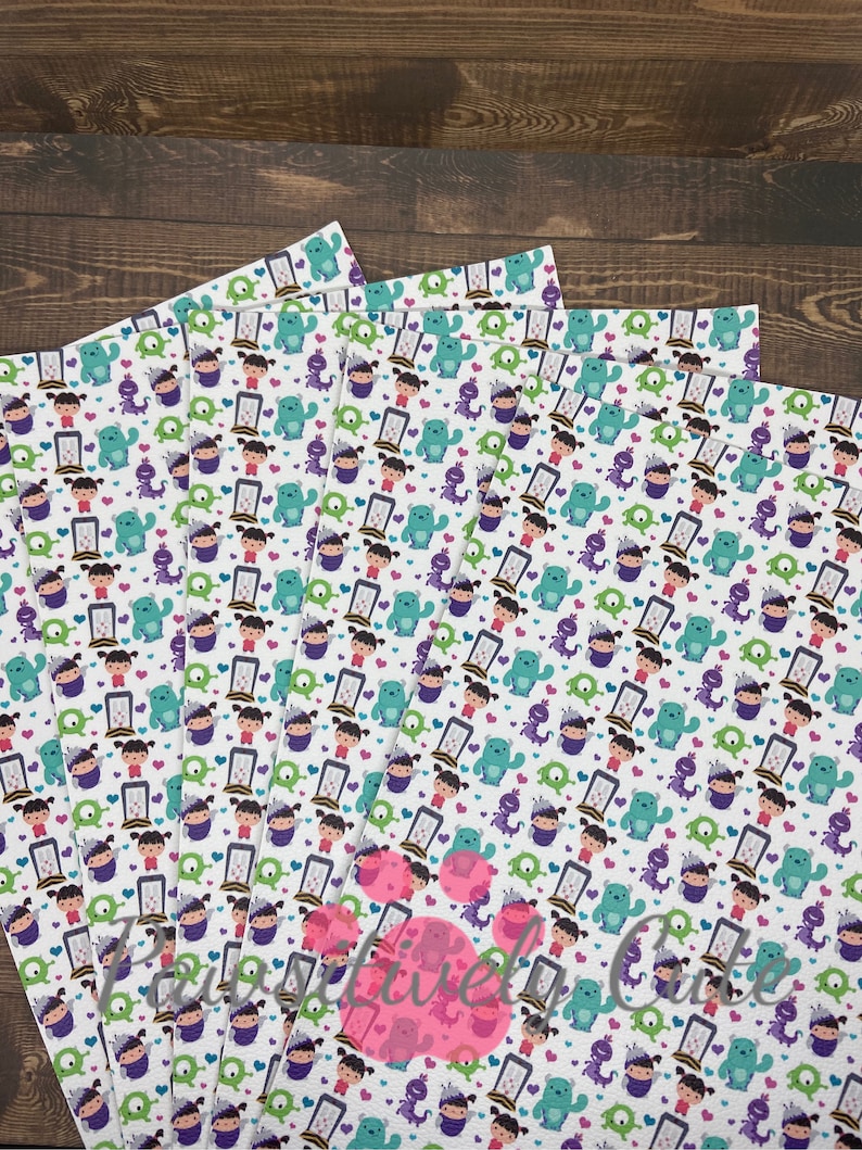 May include: A set of six white fabric sheets with a repeating pattern of cartoon characters from the movie Monsters Inc. The characters include Sully, Mike, Boo, and the door. The pattern is in shades of green, purple, blue, and pink.