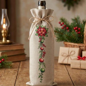 Può includere: Una borsa regalo per bottiglia di vino in lino beige con un ricamo verticale raffigurante una stella di Natale rossa, aghi di pino verdi e decorazioni natalizie rosse e verdi. La borsa è chiusa in alto con un fiocco in corda di iuta.