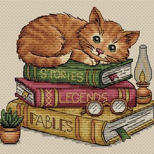 May include: Cross-stitch design of a ginger cat curled up on a stack of books. The books are labeled "Stories", "Legends", and "Fables". A small lamp, glasses, and a potted plant are also included in the design.