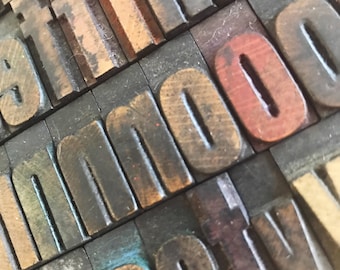 May include: Close-up of wooden letterpress blocks spelling out the word "inno" in dark brown, with a red "o" in the background.