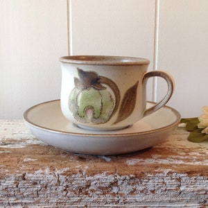 May include: A brown and white ceramic teacup and saucer with a floral design. The cup has a brown handle and the saucer has a slightly raised edge.