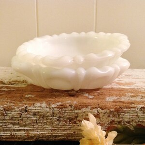 May include: A white milk glass dish with a scalloped edge. The dish is made of two pieces, one nested inside the other.