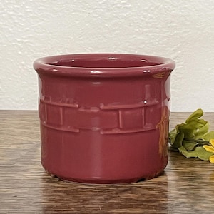 May include: A deep red ceramic butter dish with a woven pattern. The dish is made by a well-known pottery company.