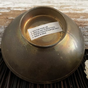 以下が含まれることがあります： 「NOT FOR FOOD USE ARTICLE MAY POISON FOOD FOR DECORATIVE PURPOSE ONLY MADE IN INDIA」とラベルが付いた真鍮製のボウルです。