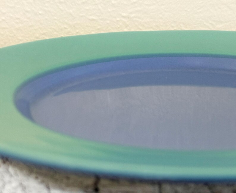 May include: A blue and green ceramic plate with a smooth, glossy finish.