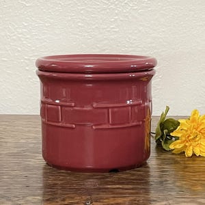 May include: A red ceramic storage jar with a lid. The jar has a basket weave pattern and is made by a well-known pottery company.