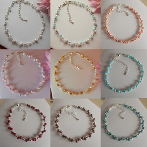 May include: Nine anklets with different coloured beads. The anklets are made with small, round beads in various colours, including white, turquoise, peach, gold, pink, red, brown, and green. Each anklet has a silver clasp.