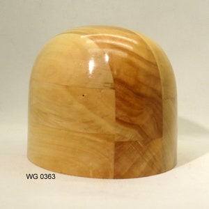 Op de afbeelding: Een houten hoedenblok met een afgeronde bovenkant en een cilindrische basis. Het hoedenblok is gemaakt van lichte en donkere houten stukken, waardoor een patchwork-effect ontstaat. Het oppervlak is glad en glanzend. De tekst "WG 0363" is zichtbaar op de basis.