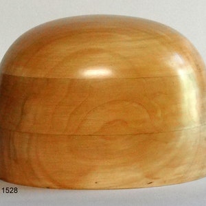Puede incluir: Un bloque de sombrero de madera marrón claro, una herramienta utilizada por los sombrereros para dar forma a los sombreros.