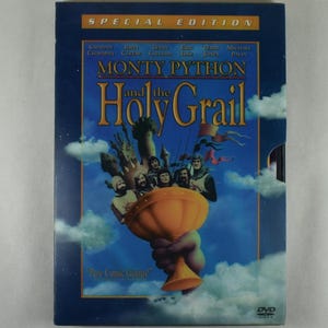May include: A DVD case for "Monty Python and the Holy Grail" in a dark blue case. The cover features a golden chalice, a castle, and several figures. The text "Special Edition" and cast names are at the top. The phrase "Pure Comic Genius!" is at the bottom.