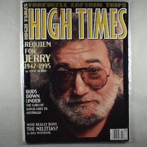 May include: A High Times magazine cover featuring a portrait of a man with glasses and a beard. The cover includes the text "FAREWELL CAPTAIN TRIPS" and "REQUIEM FOR JERRY 1942-1995". Additional text includes "BUDS DOWN UNDER" and "WHO REALLY RUNS THE MILITIAS?"