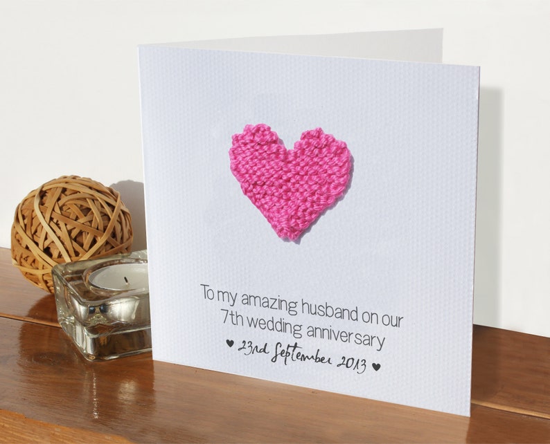 May include: A white card with a pink knitted heart and the text "To my amazing husband on our 7th wedding anniversary &hearts; 23rd September 2013 &hearts;".