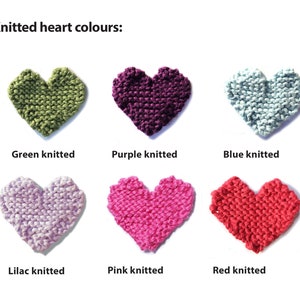 May include: Six knitted hearts in different colors: green, purple, blue, lilac, pink, and red. The hearts are arranged in two rows of three.