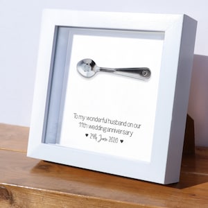 Op de afbeelding: Een wit ingelijst beeld met een zilveren lepel erin. Het beeld heeft de tekst "To my wonderful husband on our 11th wedding anniversary ♥ 29th June 2020 ♥".
