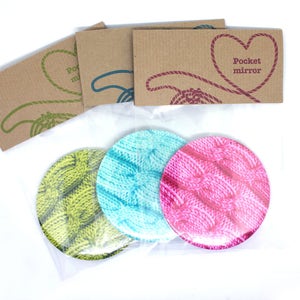 Puede incluir: Tres espejos de bolsillo redondos con un patrón de punto. Los espejos son verde, azul y rosa. El paquete incluye una tarjeta que dice "Espejo de bolsillo".